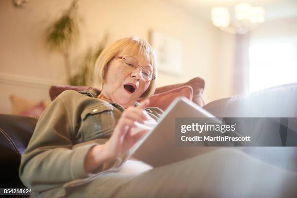 tense times playing online games - surprised woman looking at tablet stock pictures, royalty-free photos & images