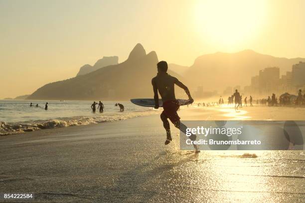 surfer running to the sea - ipanema beach imagens e fotografias de stock