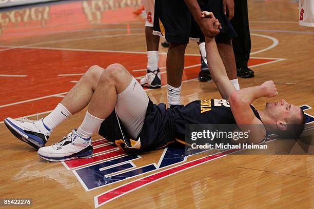 Alex Ruoff of the West Virginia Mountaineers lays on the court towards the end of the game against the Syracuse Orange during the semifinal round of...