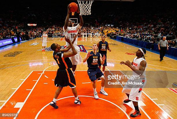 Jonny Flynn of the Syracuse Orange drives to the hoop against Da'Sean Butler and Alex Ruoff of the West Virginia Mountaineers during the semifinal...