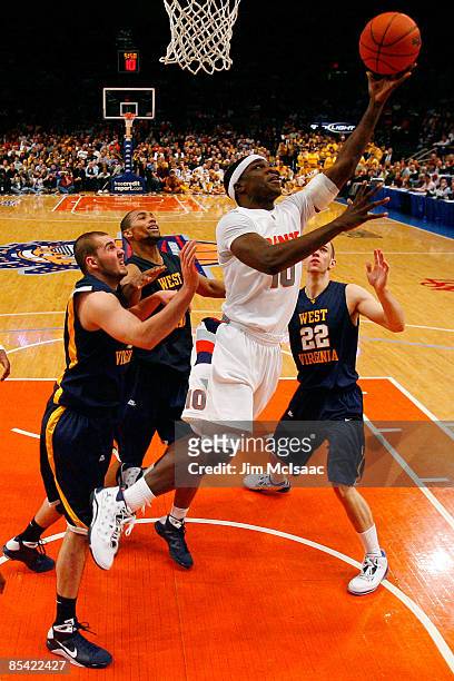 Jonny Flynn of the Syracuse Orange drives to the hoop against Cam Thoroughman, Da'Sean Butler and Alex Ruoff of the West Virginia Mountaineers during...