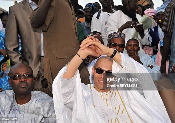 Karim Wade, son of Senegal president Abdoulaye Wade, flanked by his friend Ablaye Racine Kane , waves his supporters in Dakar on March 13, 2009 for...