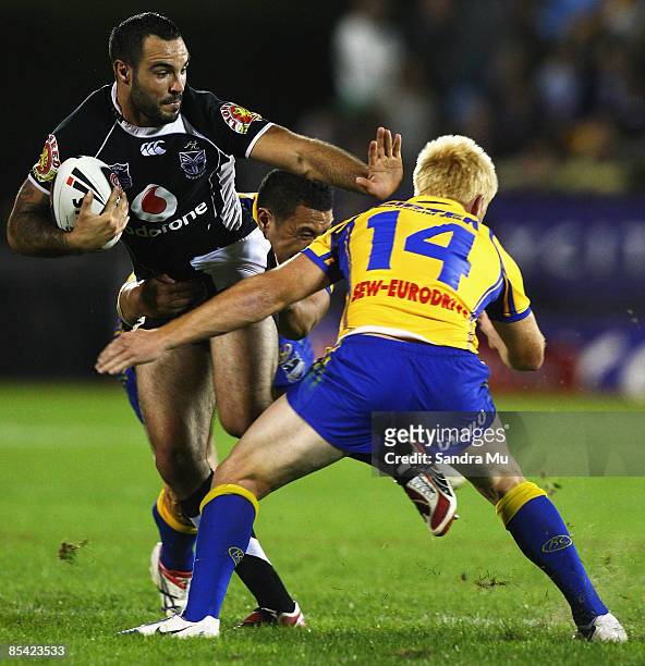 Wade McKinnon of the Warriors fends off Kris Keating of the Eels during the round one NRL match between the Warriors and the Parramatta Eels at Mt...
