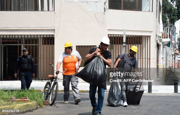 People leave a damaged building after being allowed in to get belongings, a week after a magnitude 7.1 quake struck central Mexico, in Mexico City on...