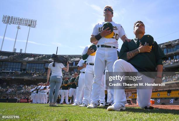 Bruce Maxwell of the Oakland Athletics kneels in protest next to teammate Mark Canha duing the singing of the National Anthem prior to the start of...