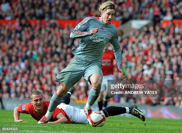Liverpool's Spanish forward Fernando Torres beats Manchester United's Serbian defender Nemanja Vidic to score the equalising goal during their...