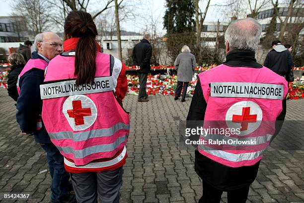 Specially trained members of the Red Cross talk to each other as mourners visit outside the local high school on March 14, 2009 in Winnenden,...
