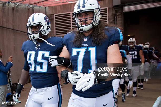 David King and Dennis Kelly of the Tennessee Titans walk out of the tunnel with arms locked before a game against the Seattle Seahawks at Nissan...