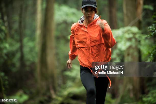 female runner in the woods - orange hat stock pictures, royalty-free photos & images