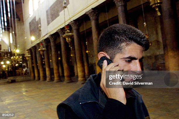 Palestinian uses an Israeli "Cellcom" mobile phone November 13, 2001 in the Church of the Nativity, the traditional site of Jesus's birth, in the...