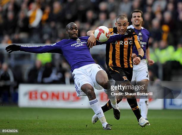Sebastien Bassong of Newcastle United and Craig Fagan of Hull City battle for the ball during the Barclays Premier League match between Hull City and...
