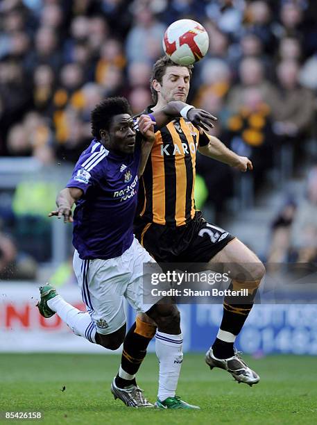 Obafemi Martins of Newcastle United and Sam Ricketts of Hull City challenge for the ball during the Barclays Premier League match between Hull City...