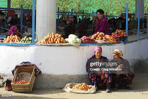 Traders sit at a market November 18, 2001 in Termez, Yzbekistan near the Yzberistan-Afghanian border.