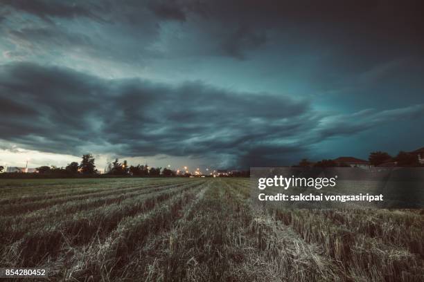 panoramic view of storm over the farm - dark evening sky stock-fotos und bilder
