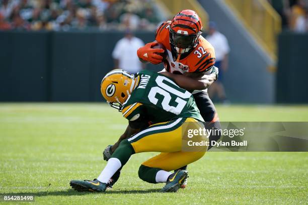 Kevin King of the Green Bay Packers attempts to tackle Jeremy Hill of the Cincinnati Bengals in the first quarter at Lambeau Field on September 24,...