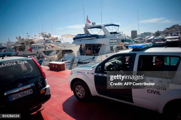 Members of the Spanish Guardia civil stand on the docks during a raid targeting the Russian mafia in the Puerto Banus marina area of the southern...