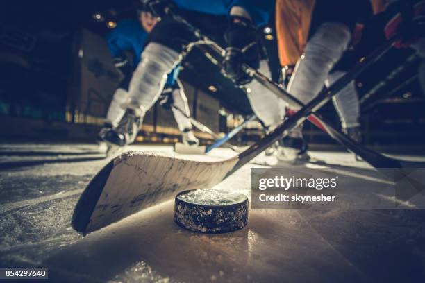 cerca del duende malicioso del hockey sobre hielo y pegue durante un partido. - hockey fotografías e imágenes de stock