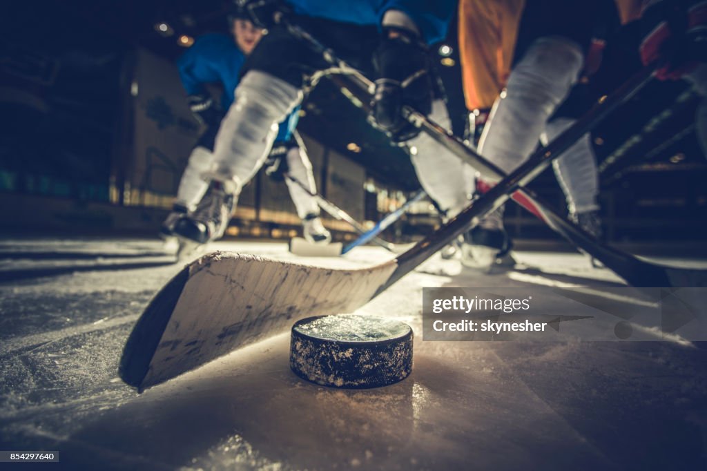 Close up of ice hockey puck and stick during a match.