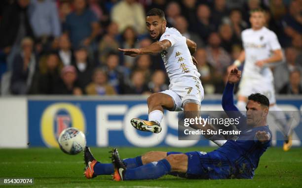 Leeds player Kemar Roofe gets a shot in at goal despite the challenge of Sean Morrison during the Sky Bet Championship match between Cardiff City and...