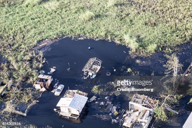 Destroyed homes and vehicles sit in floodwaters from Hurricane Maria in this aerial photograph taken above Hamacao, Puerto Rico, on Monday, Sept. 25,...