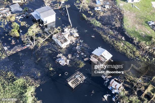 Destroyed homes and vehicles sit in floodwaters after Hurricane Maria in this aerial photograph taken above Hamacao, Puerto Rico, on Monday, Sept....