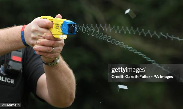 Sussex police officer demonstrates the use of a Taser during a media conference at police headquarters in Lewes, Sussex, as around 160 Sussex police...