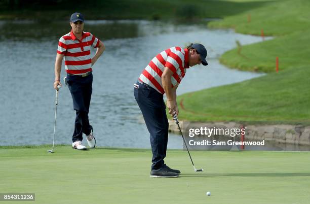 Justin Thomas of the United States Team watches teamate Phil Mickelson during a practice round prior to the Presidents Cup on September 26, 2017 at...