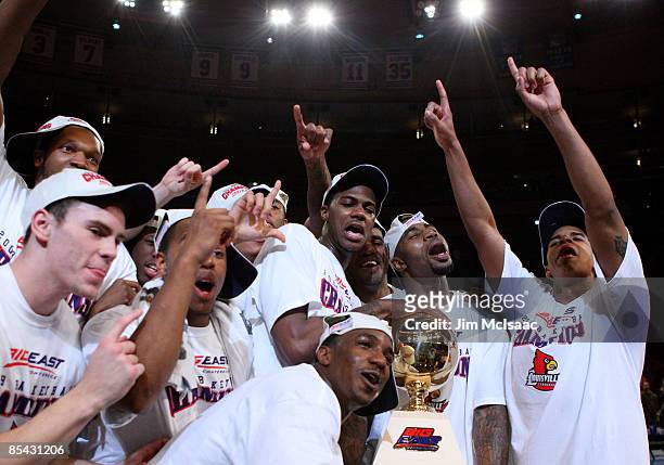 The Louisville Cardinals celebrate with the trophy after defeating the Syracuse Orange during to win championship game of the Big East Tournament at...