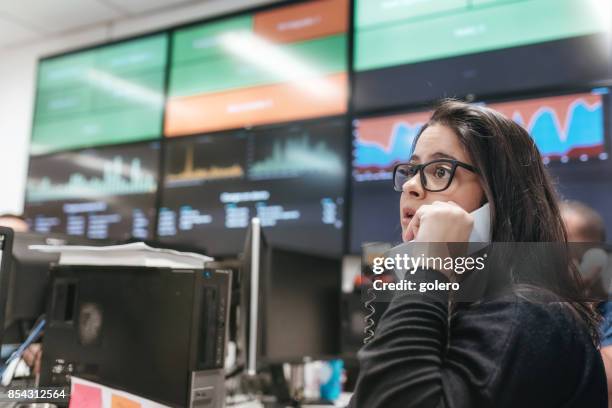 business woman talking at telephone in front of carts with business data - brazilian stock exchange stock pictures, royalty-free photos & images