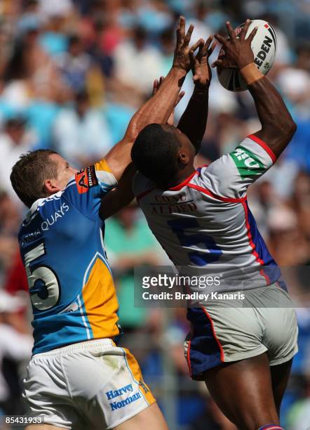 Jordan Atkins of the Titans and Akuila Uate of the Knights compete for the ball during the round one NRL match between the Gold Coast Titans and the...