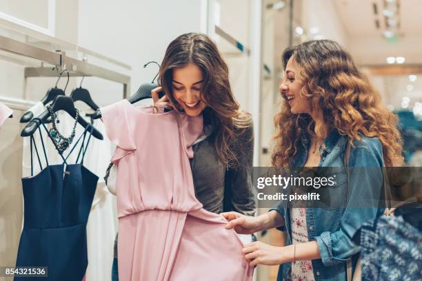 kijk naar deze prachtige jurk! - clothing store stockfoto's en -beelden