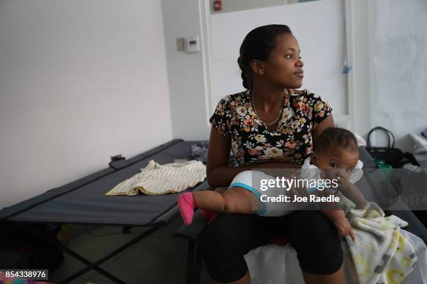 Joanne Torres sits on a cot with her daughter, Eliana Heredia, in the Centro de Servicios Integrados de Barrio Obrero shelter that was setup for...