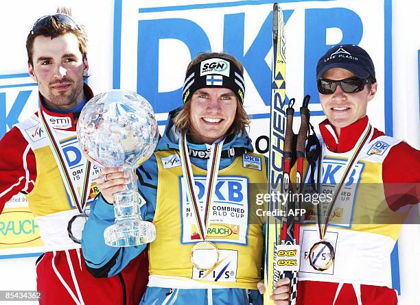 Anssi Koivuranta of Finland holding the crystal ball trophy for his ovarall victory in the Men's FIS Nordic Combined World Cup title, flanked in...