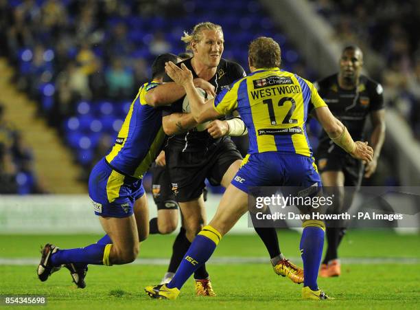 Huddersfield Giants' Eorl Crabtree is tackled by Warrington Wolves' Chris Hill and Warrington Wolves' Ben Westwood during the Super League Semi-Final...