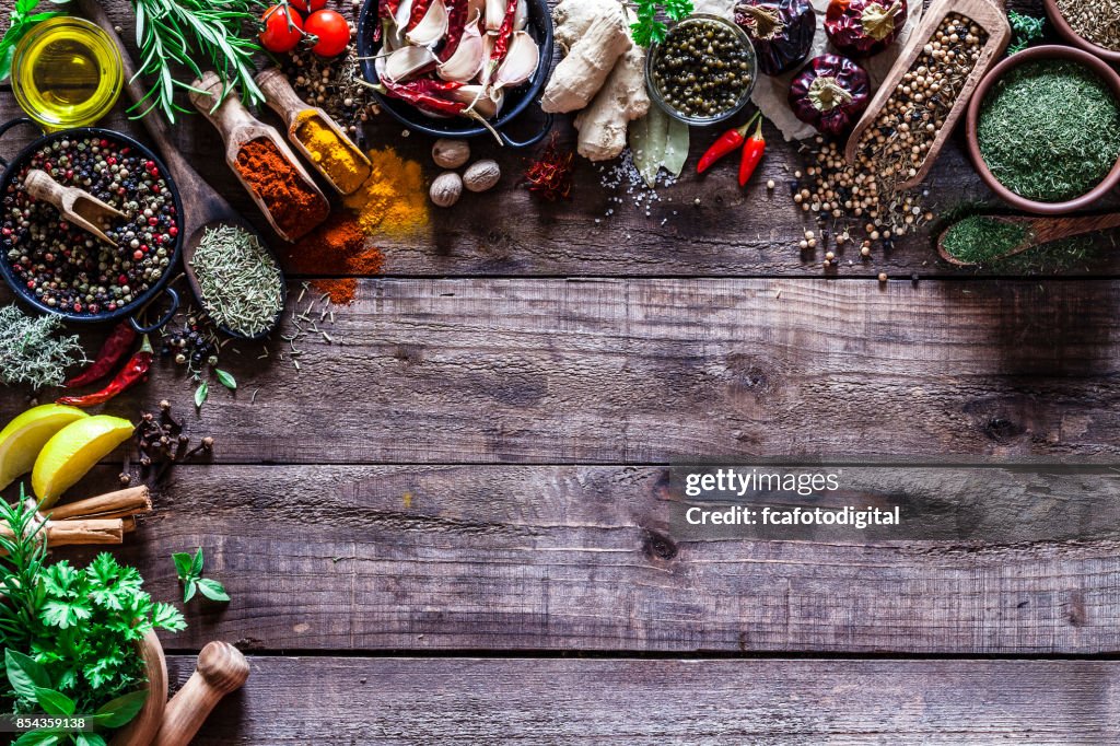 Spezie ed erbe bordo su tavolo da cucina in legno rustico