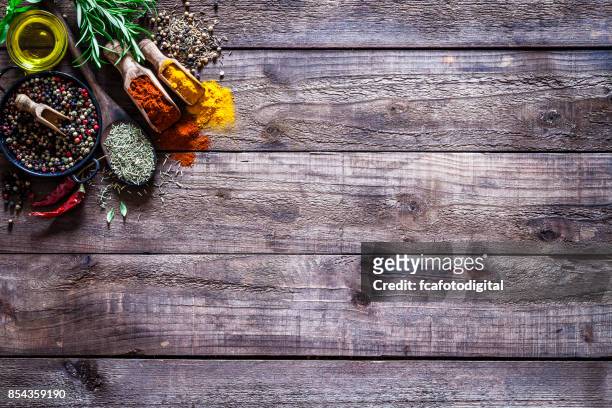especias y hierbas sobre mesa de cocina madera rústica - condiment fotografías e imágenes de stock