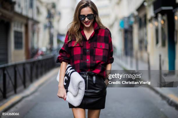 Alexandra Lapp wearing a plaid shirt by Set Fashion, mini leather skirt and a leather belt with studs by Set, oversized MCM Stark Pouch in lambskin,...