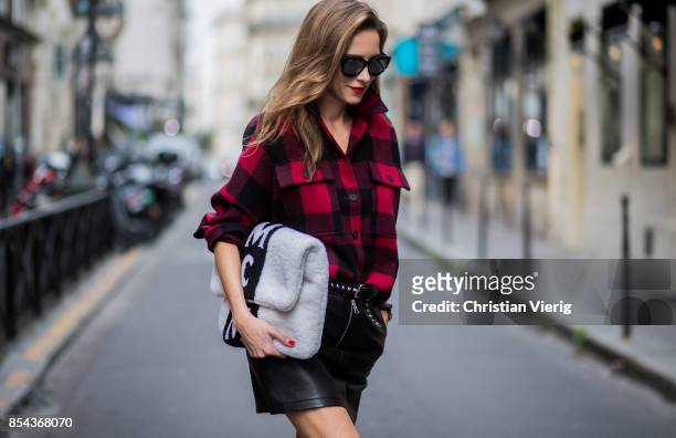 Alexandra Lapp wearing a plaid shirt by Set Fashion, mini leather skirt and a leather belt with studs by Set, oversized MCM Stark Pouch in lambskin,...