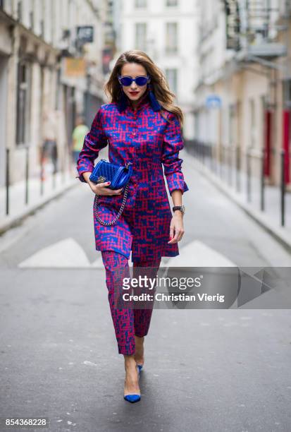 Alexandra Lapp wearing a two-piece in red and blue by Riani, a blue lacquer Chanel Boy bag, blue sunglasses by Etnia Barcelona, plexi pumps in blue...