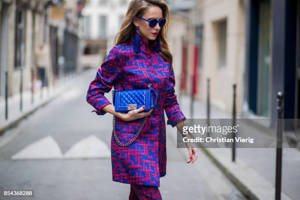 Alexandra Lapp wearing a two-piece in red and blue by Riani, a blue lacquer Chanel Boy bag, blue sunglasses by Etnia Barcelona, plexi pumps in blue...