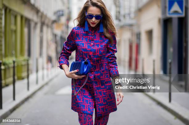 Alexandra Lapp wearing a two-piece in red and blue by Riani, a blue lacquer Chanel Boy bag, blue sunglasses by Etnia Barcelona, plexi pumps in blue...