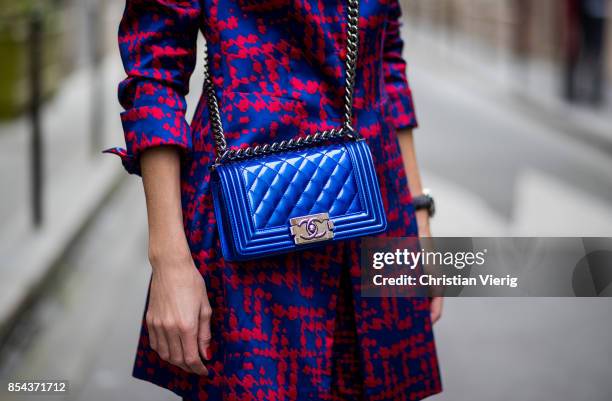 Alexandra Lapp wearing a two-piece in red and blue by Riani, a blue lacquer Chanel Boy bag, blue sunglasses by Etnia Barcelona, plexi pumps in blue...