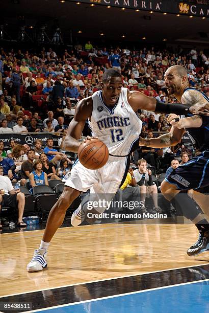 Dwight Howard of the Orlando Magic drives against Carlos Boozer of the Utah Jazz during the game on March 15, 2009 at Amway Arena in Orlando,...