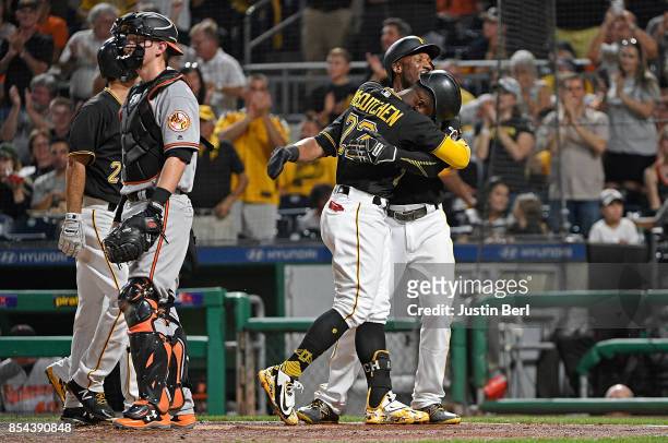 Andrew McCutchen of the Pittsburgh Pirates is hugged by Starling Marte as he crosses home plate after hitting a grand slam home run in the second...