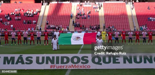 Players of Chivas and Lobos pose behind a Mexican flag and show support to Mexican society after the earthquake that struck Mexico City, Puebla and...