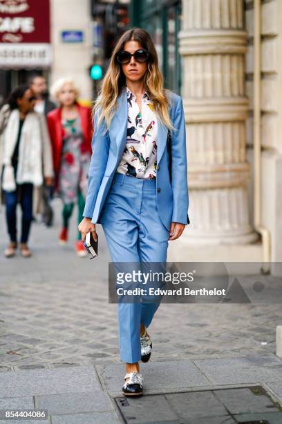 Guest wears sunglasses, a blue blazer jacket, suit pants, a bird print shirt, outside Anrealage, during Paris Fashion Week Womenswear Spring/Summer...