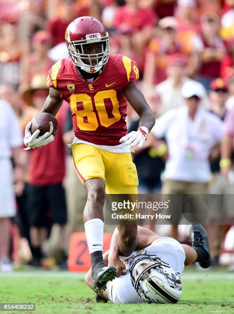 Deontay Burnett of the USC Trojans runs after a catch as Asantay Brown of the Western Michigan Broncos attempts to make a tackle during the fourth...
