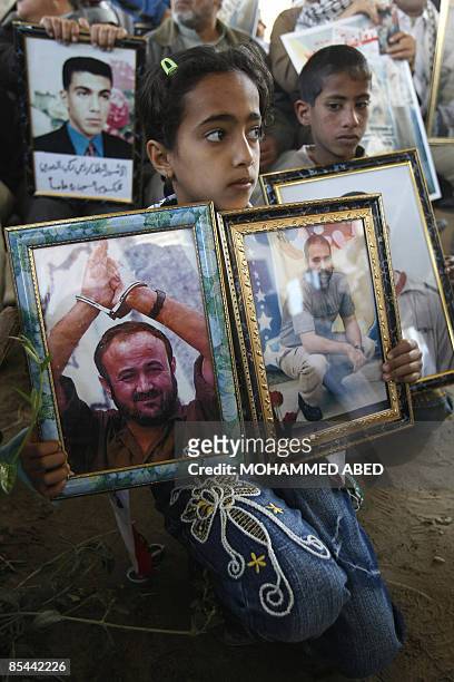 Palestinian girl holds a picture of a relative and of jailed Fatah leader Marwan Barghuti during a protest at the Red Cross offices in Gaza City...