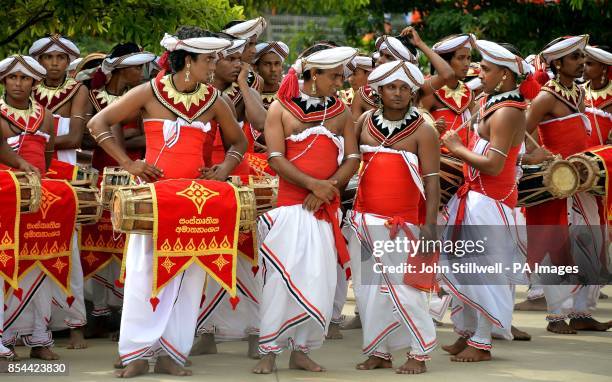 Group of men dressed in traditional costume, wait to perform at the opening ceremony of the Commonwealth Heads of Government Meeting at the Nelum...