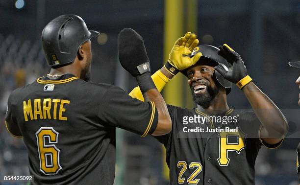 Andrew McCutchen of the Pittsburgh Pirates high fives with Starling Marte after hitting a three run home run in the sixth inning during the game...